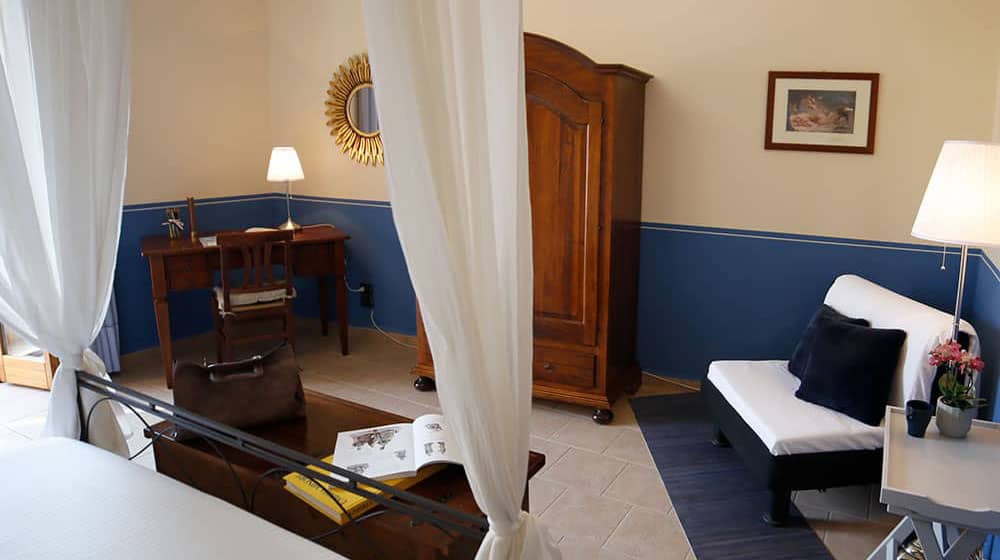 Clio. Master bedroom with four-poster double bed. Le Muse Holiday Apartments Bevagna historic center