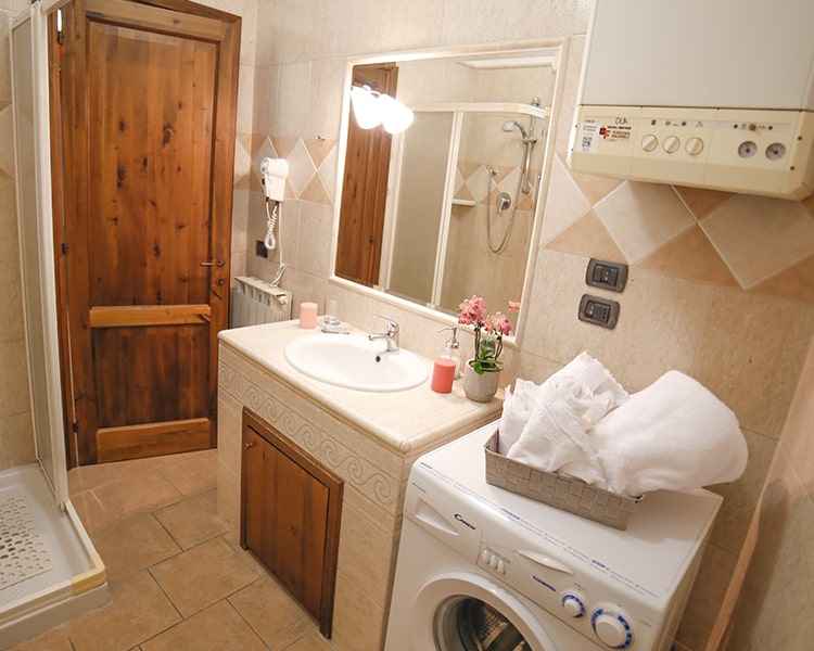 Bathroom with shower and washing machine - Holiday apartment Le Muse Bevagna, Umbria, Italy